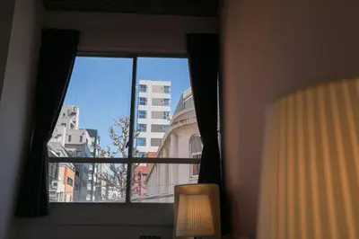 a window with a view of a city at hostel DEN in Tokyo