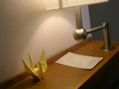 a desk with a lamp and a paper on it at Toshi Center Hotel in Tokyo