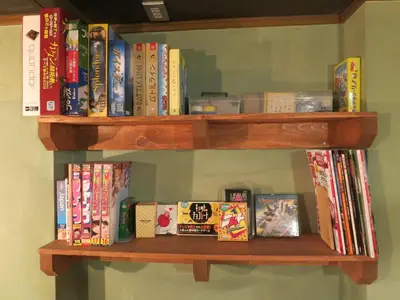 a wooden book shelf filled with lots of books at No Borders Hostel in Tokyo