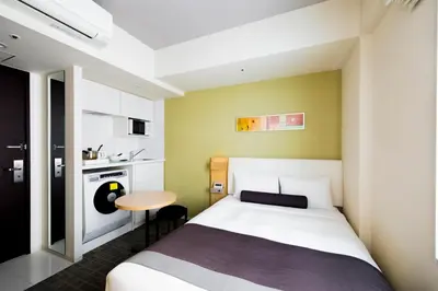 a small bedroom with a bed and a small table at Tokyu Stay Kamata - Tokyo Haneda in Tokyo