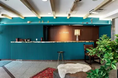 a lobby with a green wall and a bar at Hotel Toms in Tokyo
