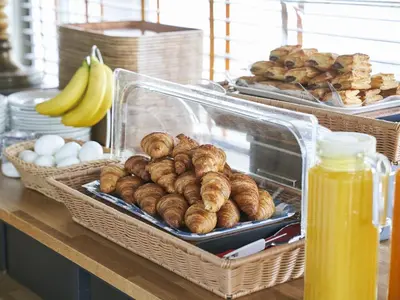 a table with baskets of pastries and eggs and bananas at Hotel Toms in Tokyo