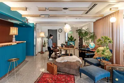 a woman is standing in a living room at Hotel Toms in Tokyo