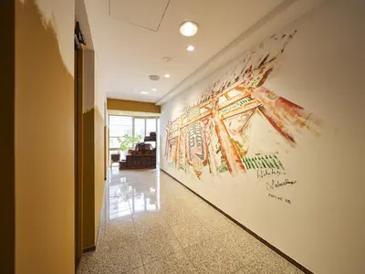 a hallway with a large painting on the wall at Hotel Toms in Tokyo