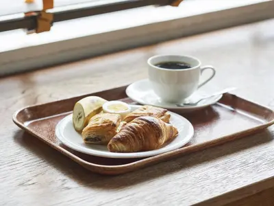 a tray with a plate of pastries and a cup of coffee at Hotel Toms in Tokyo