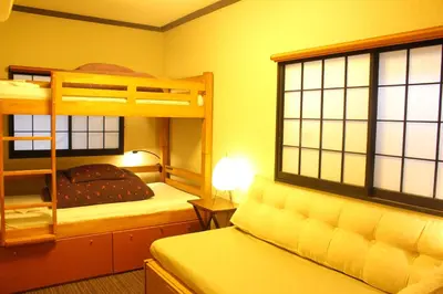 a bedroom with two bunk beds and a lamp at K's House Tokyo Oasis - Quality Hostel in Asakusa in Tokyo