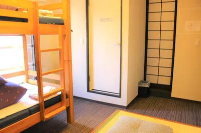 a room with two bunk beds and a mirror at K's House Tokyo Oasis - Quality Hostel in Asakusa in Tokyo