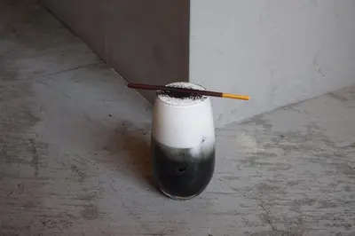 a bottle with a cigarette in it sitting on the floor at Book And Bed Tokyo Shinjuku in Tokyo