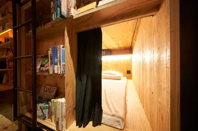 a bedroom with a mirror in a book shelf at Book And Bed Tokyo Shinjuku in Tokyo