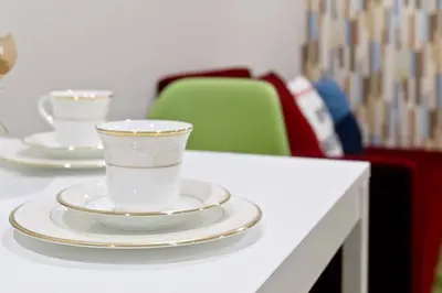 two cups and plates on a table with chairs at House In Azabu in Tokyo