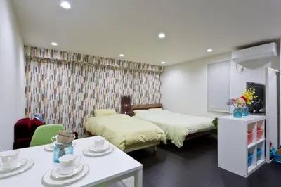 a bedroom with two beds and a table with dishes on it at House In Azabu in Tokyo