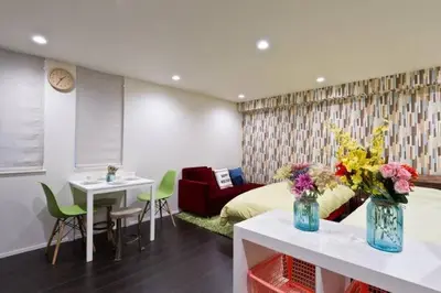 a room with a bed and a table with flowers on it at House In Azabu in Tokyo