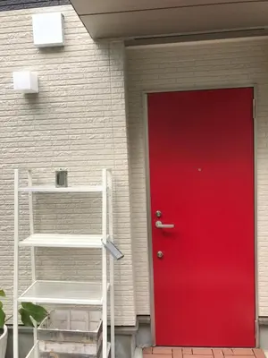 a red door in front of a house at House In Azabu in Tokyo