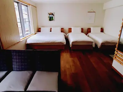 a room with four beds in it with a window at Rooms in Tokyo