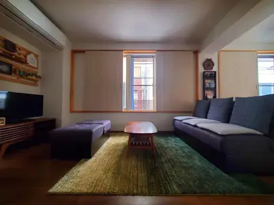 a living room with a couch and a tv at Rooms in Tokyo