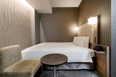 a hotel room with a bed and a table and a chair at Hotel Keihan Tsukiji Ginza Grande in Tokyo