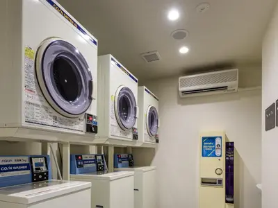 a laundry room with three washing machines on a wall at MIMARU Tokyo Nihombashi Suitengumae in Tokyo