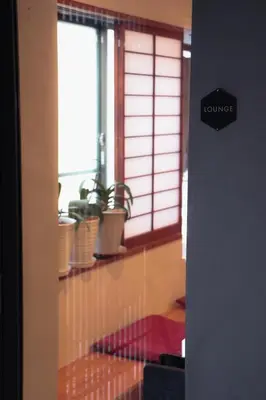 a room with a window with potted plants on a shelf at Ito Ryokan in Tokyo