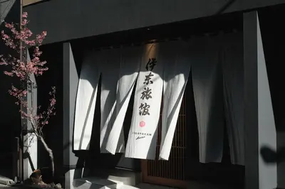 a door with white curtains and a sign on it at Ito Ryokan in Tokyo