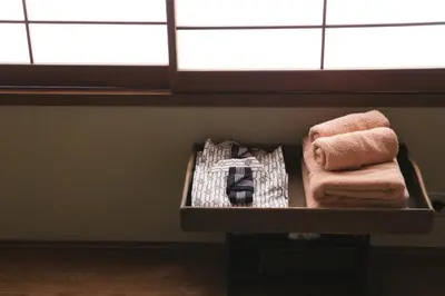 a shelf with towels in a room with a window at Ito Ryokan in Tokyo