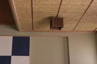 a room with a ceiling fan and a room with a wall at Ito Ryokan in Tokyo