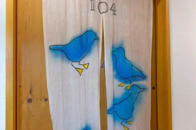 a wooden door with two blue birds painted on it at \u30b2\u30b9\u30c8\u30cf\u30a6\u30b9\u9ad8\u5186\u5bfa\u7d14\u60c5\u30db\u30c6\u30eb -Guest House Koenji Junjo Hotel- in Tokyo