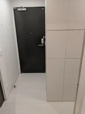 a black door in a white room with a tile floor at Port House Shibuya in Tokyo