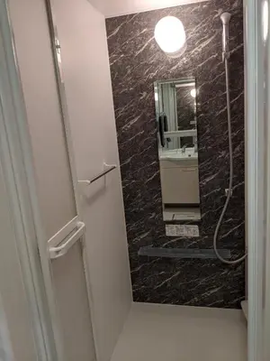 a bathroom with a large mirror and a shower at Port House Shibuya in Tokyo