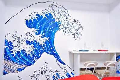 a large wave mural in a dining room at Square Shibuya 407 in Tokyo