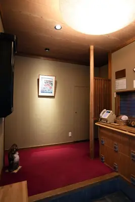 a room with a tv and a red carpet at Ryokan Sansuiso in Tokyo
