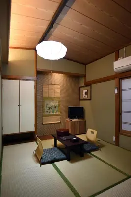 a living room with a table and chairs at Ryokan Sansuiso in Tokyo