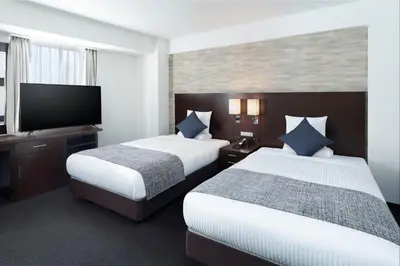 a hotel room with two beds and a flat screen tv at ART HOTEL Nippori Lungwood in Tokyo