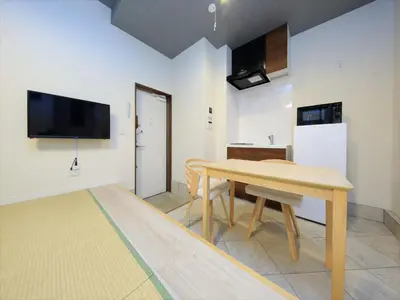 a dining room with a table and a television on the wall at COTO Tokyo Asakusa 4 in Tokyo