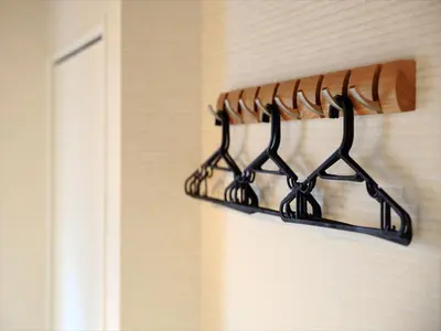 a black rack of hangers on a wall at COTO Tokyo Asakusa 4 in Tokyo