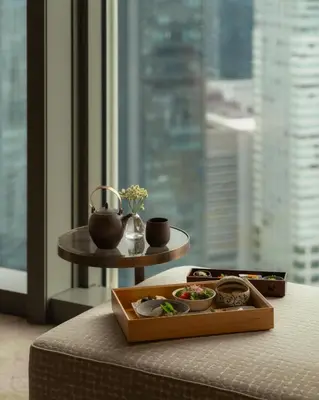 a tray of food on a bed next to a window at Mandarin Oriental, Tokyo in Tokyo