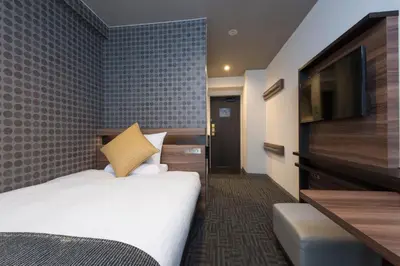 a hotel room with a bed and a flat screen tv at HOTEL MYSTAYS Gotanda in Tokyo