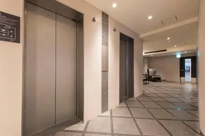 an office hallway with doors and tile floors at HOTEL MYSTAYS Gotanda in Tokyo