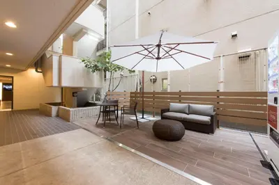 a living room with a couch and a large umbrella at HOTEL MYSTAYS Gotanda in Tokyo