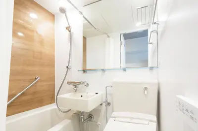 a bathroom with a sink and a toilet and a mirror at HOTEL MYSTAYS Gotanda in Tokyo