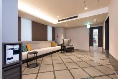 a living room with a couch and a chair at HOTEL MYSTAYS Gotanda in Tokyo