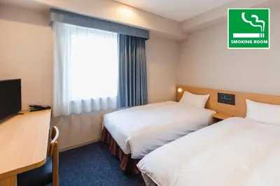 a hotel room with two beds and a television at Sotetsu Fresa Inn Tokyo-Akasaka in Tokyo