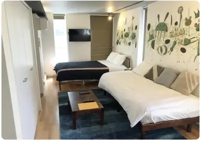 a hotel room with two beds and a table at The Aoca Tokyo Sanno in Tokyo