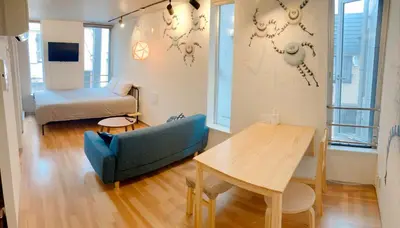 a living room with a couch and a table and a bed at The Aoca Tokyo Sanno in Tokyo