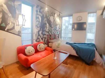 a living room with a red couch and a table at The Aoca Tokyo Sanno in Tokyo