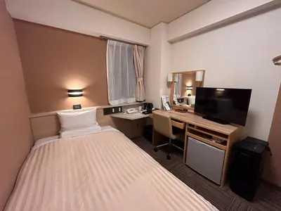 a hotel room with a bedroom with a bed and a desk at Hotel Route-Inn Shinagawa-Oimachi in Tokyo