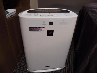 a washing machine is sitting next to a bed at Hotel Route-Inn Tokyo Asagaya in Tokyo