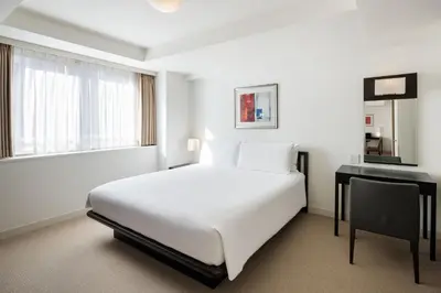 a white bedroom with a bed and a desk at Oakwood Residence Aoyama Tokyo in Tokyo