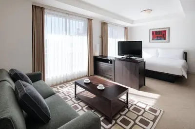 a living room with a couch and a bed at Oakwood Residence Aoyama Tokyo in Tokyo