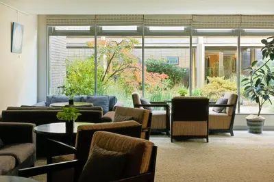 a waiting room with chairs and tables and windows at Oakwood Residence Aoyama Tokyo in Tokyo