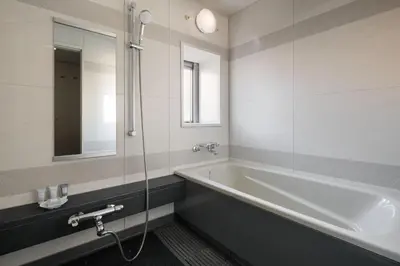 a bathroom with a tub and a glass shower at Oakwood Residence Aoyama Tokyo in Tokyo